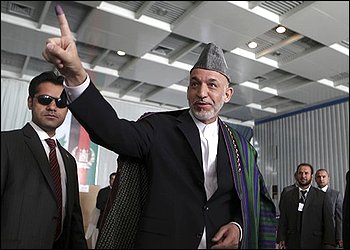 Afghan presidential candidate and current President Hamid Karzai shows his ink-stained finger after voting in the presidential election at a polling station in Kabul, Afghanistan, Thursday, Aug. 20, 2009. Thousands of polling centers across Afghanistan opened for voting Thursday, and millions of Afghans were expected to choose a new president to lead a nation plagued by armed insurgency, drugs, corruption and a feeble government. (AP Photo/Rafiq Maqbool)